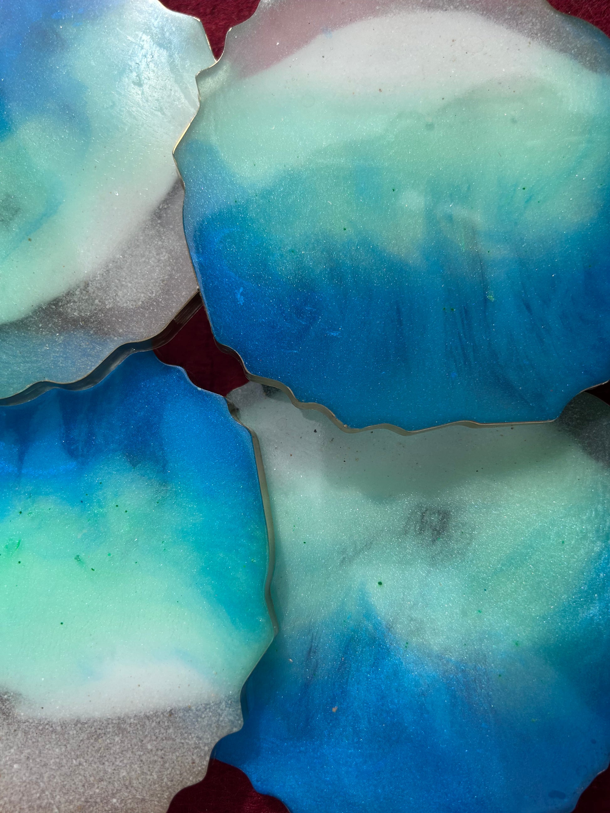 Close-up of blue and green marbled soap bars on a red surface