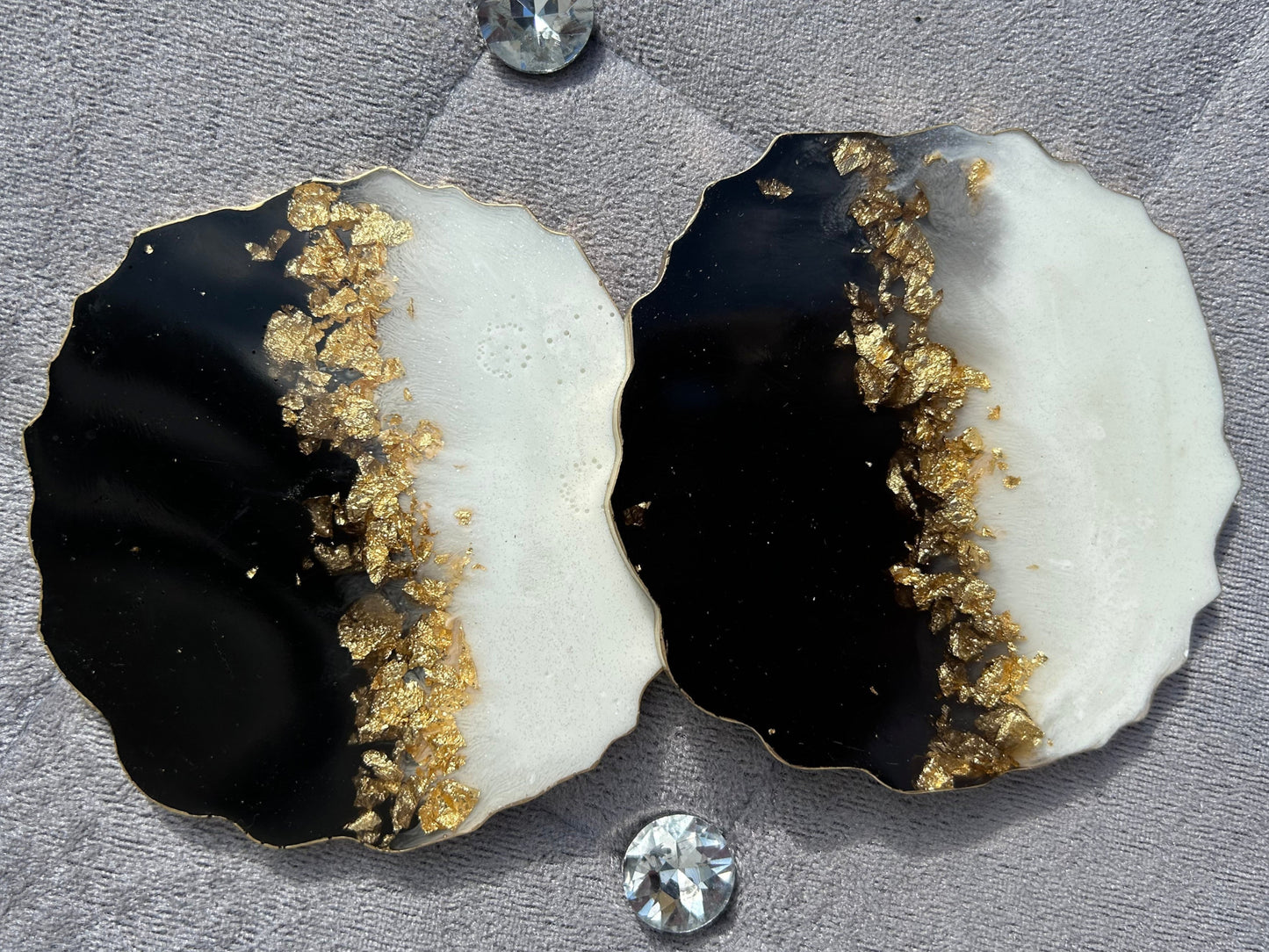 Black, white, and gold stone with embedded diamonds on a gray surface