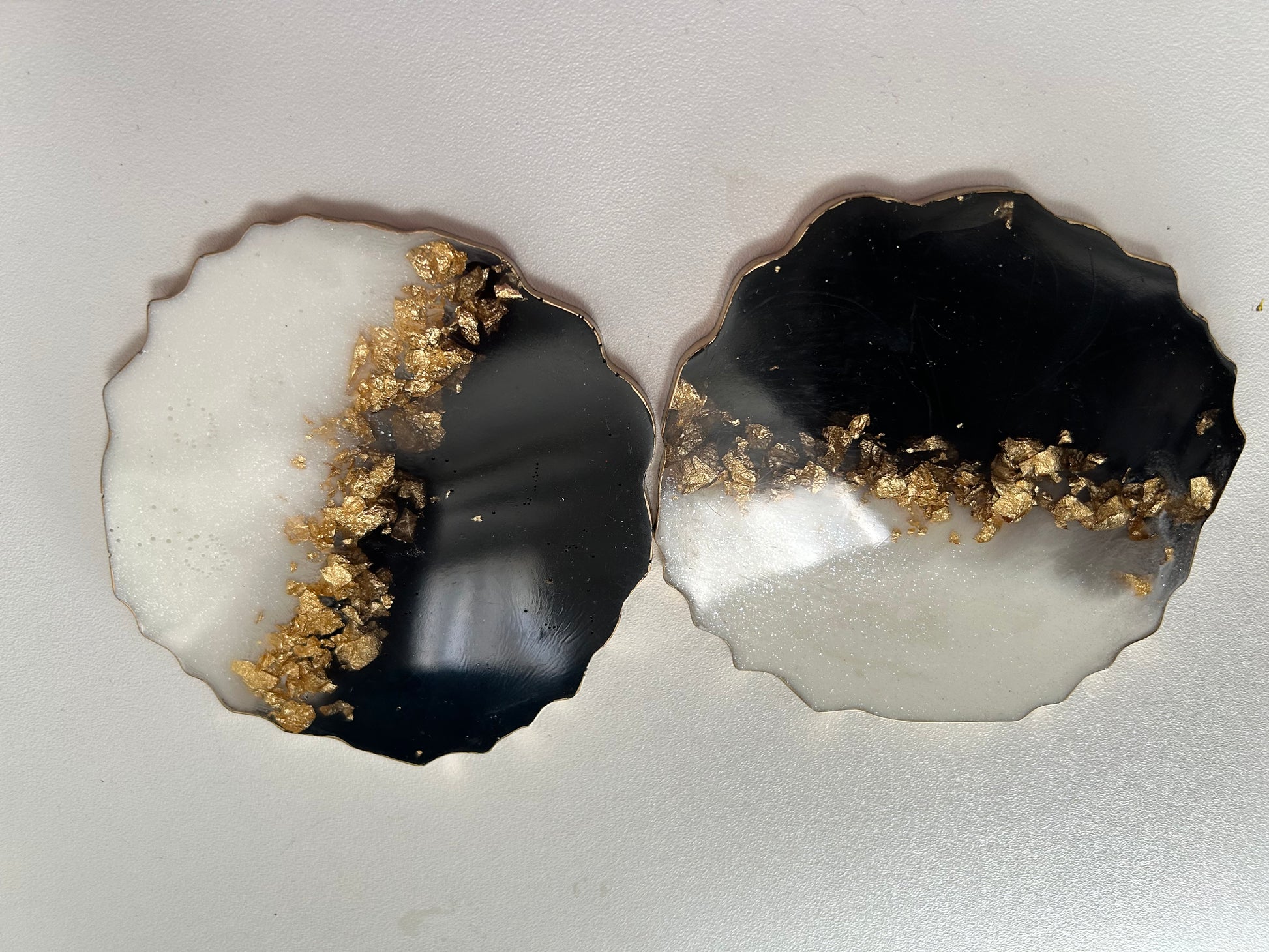 Two agate slices with gold inclusions on a gray background
