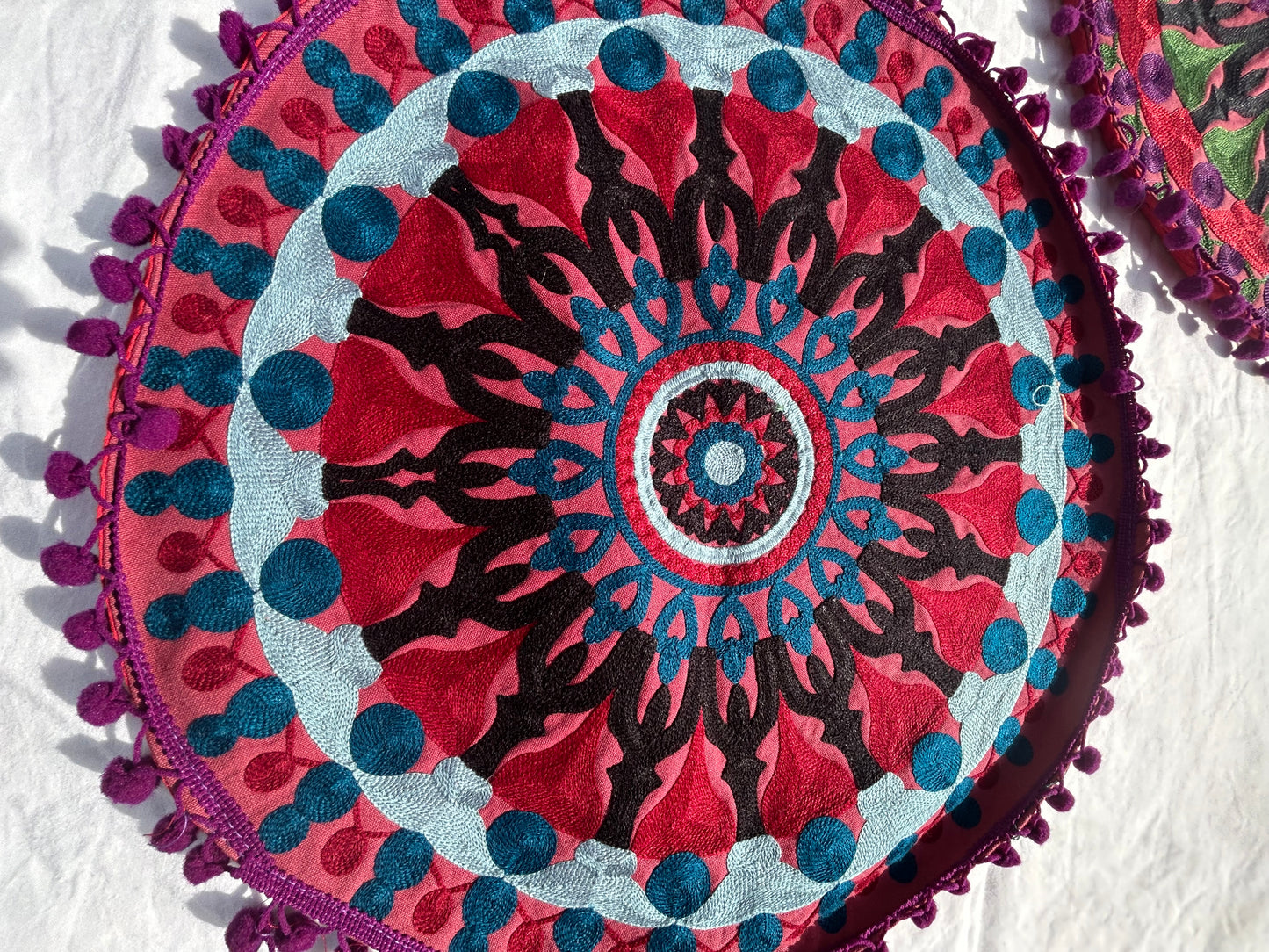 Decorative circular pillow with mandala pattern on a white background